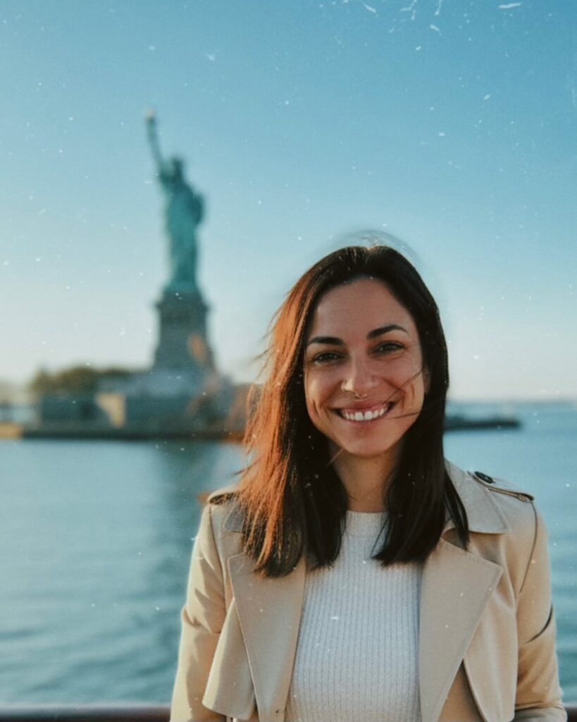 Photo of AJ in front of statue of liberty